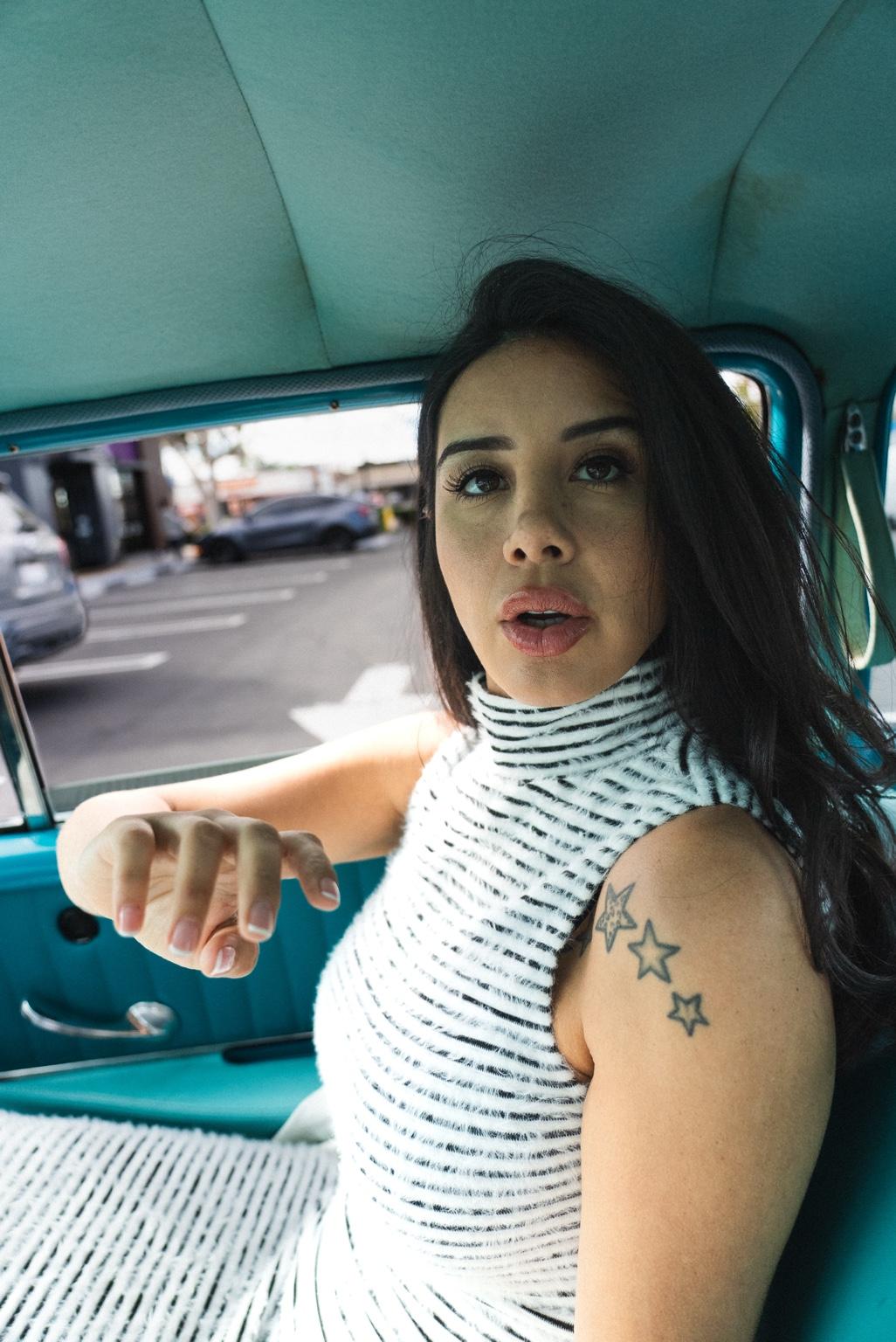 Natasha Valentina seated inside a turquoise car