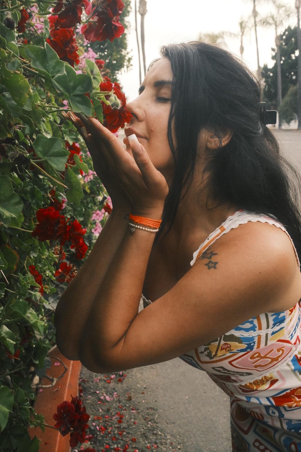 Natasha Valentina smelling red flowers